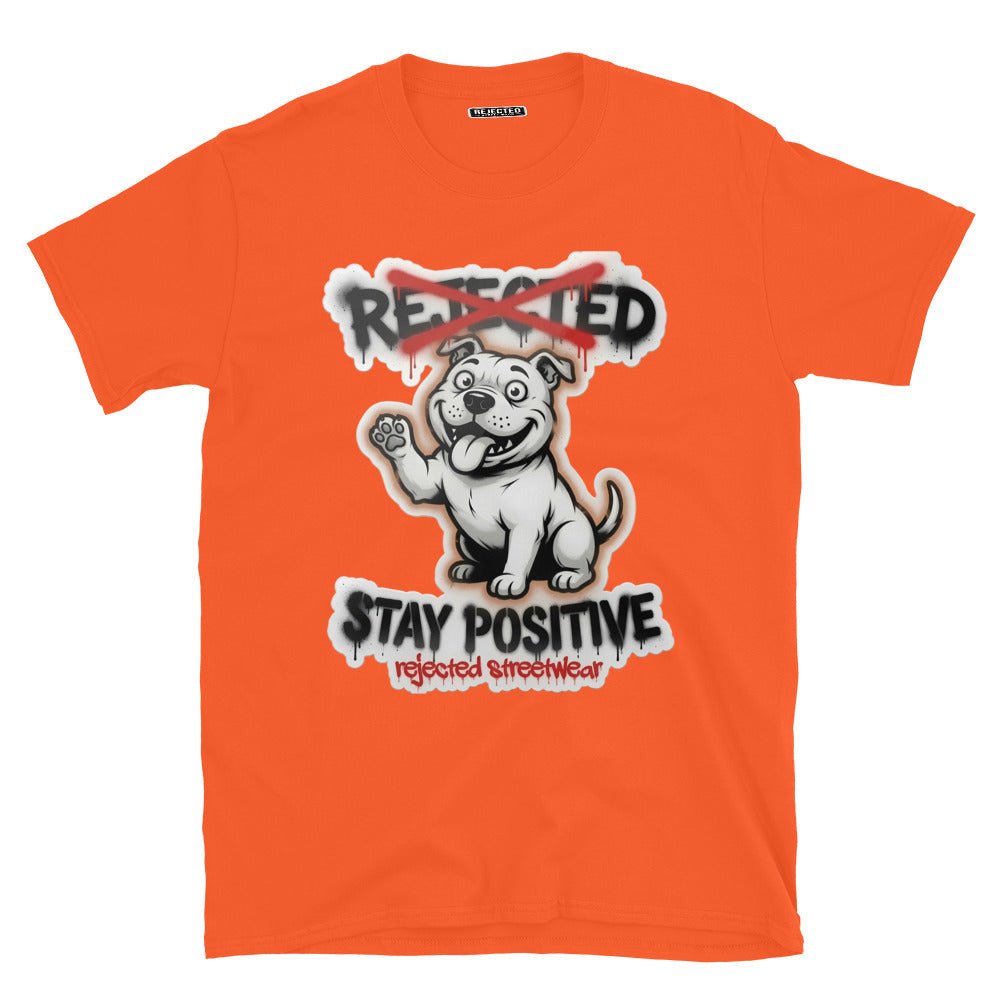 Stay Positive pit bull tee — white bully pup sitting with one paw raised, REJECTED crossed out in red