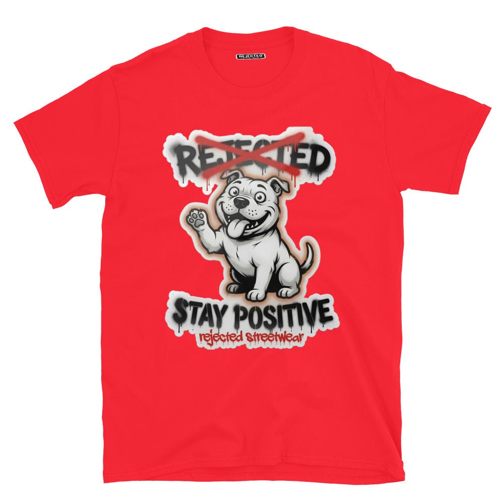 Stay Positive pit bull tee — white bully pup sitting with one paw raised, REJECTED crossed out in red
