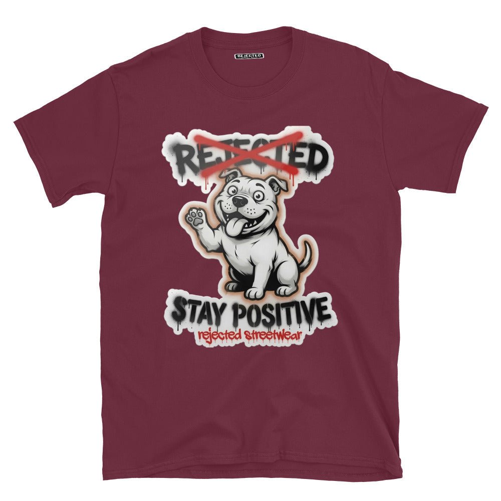 Stay Positive pit bull tee — white bully pup sitting with one paw raised, REJECTED crossed out in red