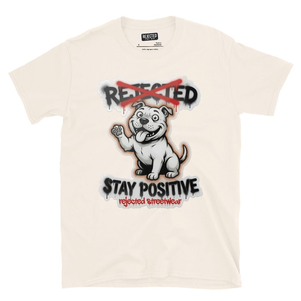 Stay Positive pit bull tee — white bully pup sitting with one paw raised, REJECTED crossed out in red