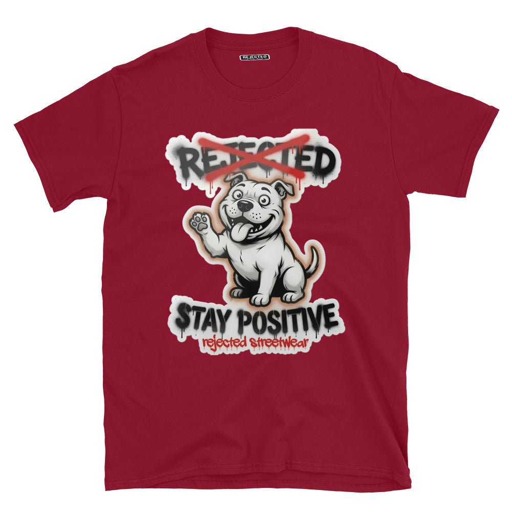 Stay Positive pit bull tee — white bully pup sitting with one paw raised, REJECTED crossed out in red