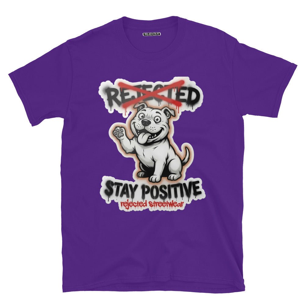 Stay Positive pit bull tee — white bully pup sitting with one paw raised, REJECTED crossed out in red