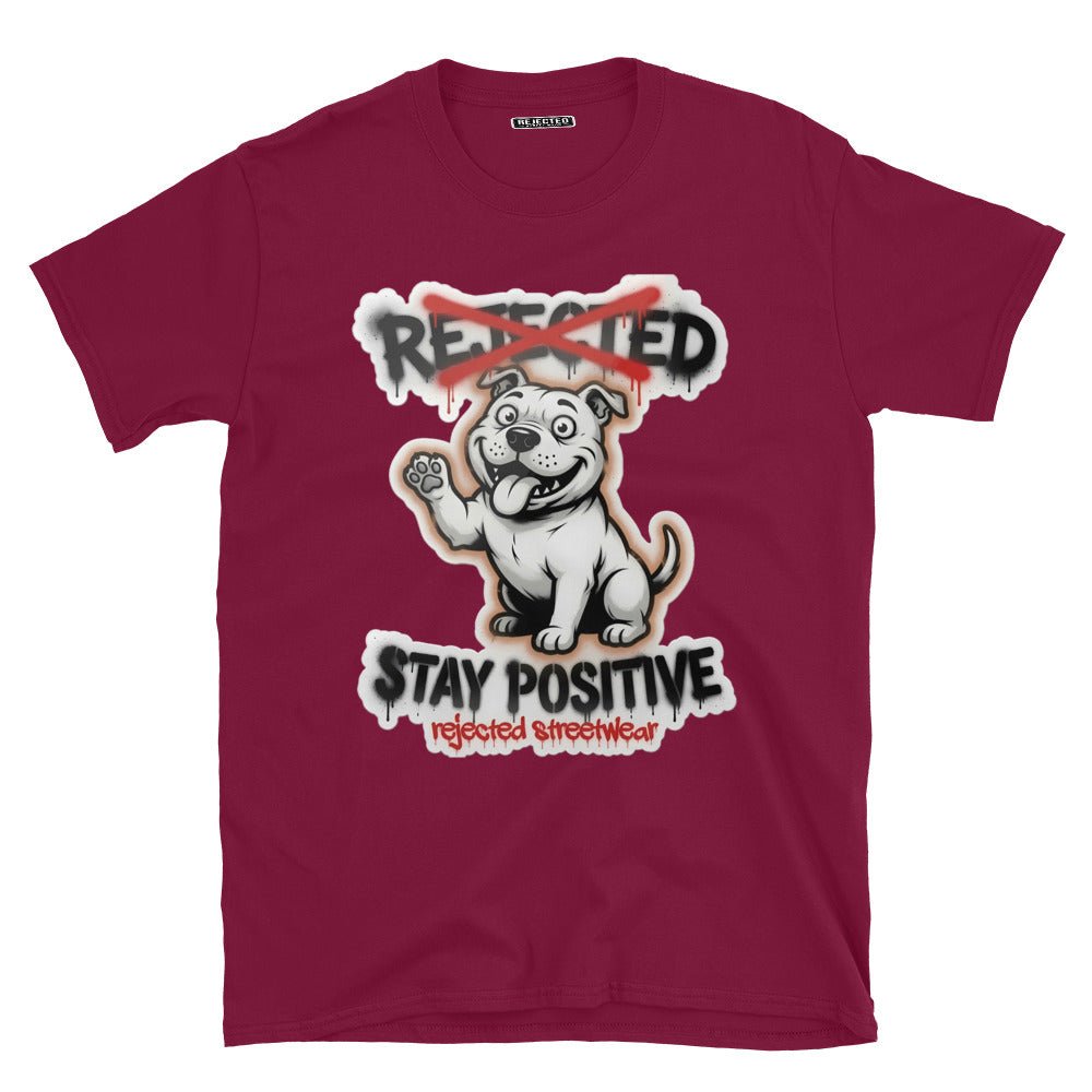 Stay Positive pit bull tee — white bully pup sitting with one paw raised, REJECTED crossed out in red
