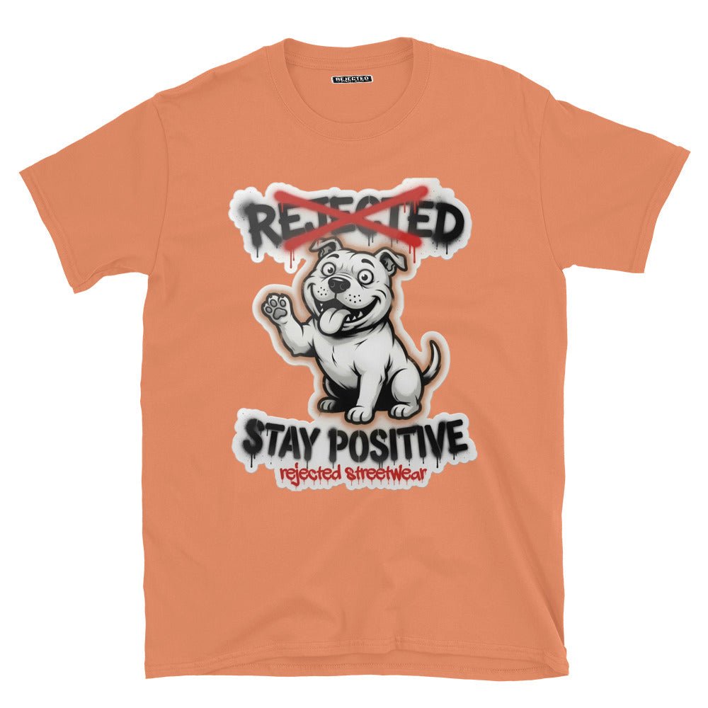 Stay Positive pit bull tee — white bully pup sitting with one paw raised, REJECTED crossed out in red