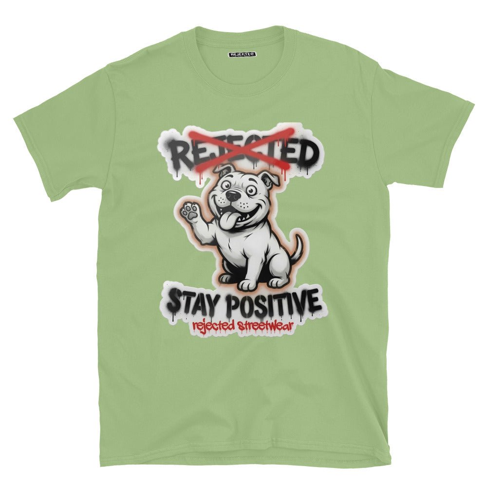Stay Positive pit bull tee — white bully pup sitting with one paw raised, REJECTED crossed out in red